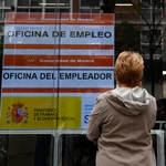 Una mujer observa un anuncio de una Oficina del Servicio Público de Empleo Estatal (SEPE