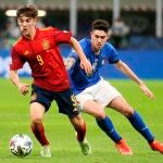 Gavi, perseguido por Alessandro Bastoni en la imagen, se convirtió en el jugador más joven en debutar con la selección