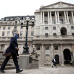 Una persona camina delante del Banco de Inglaterra