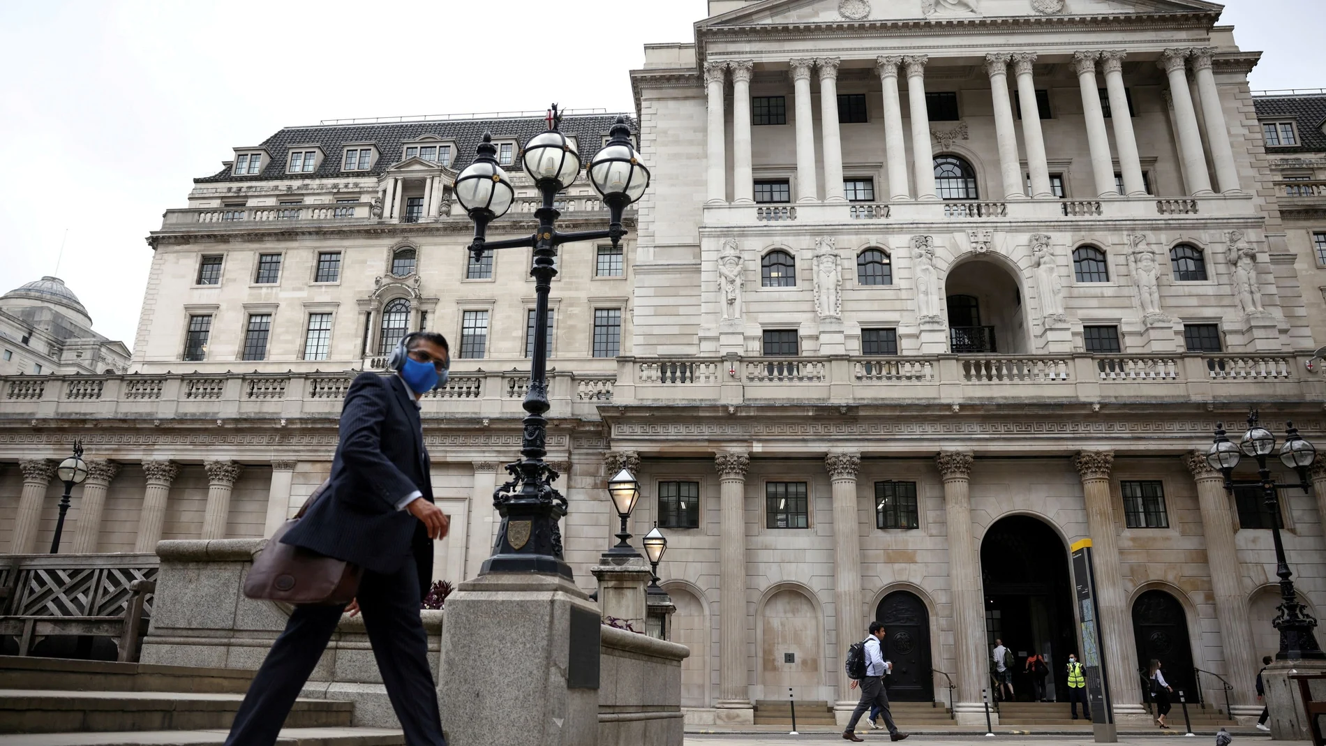 Una persona camina delante del Banco de Inglaterra
