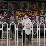 A woman wearing mask past by an advertisement for the patriotic movie "My People, My Parents" at a cinema in Beijing, China, Friday, Oct. 8, 2021. China saw a major dip in travel over the past week's National Day vacation. People staying home appeared to have chosen the cinema instead, with a patriotic Korean War film taking in more than 3.45 billion yuan ($535 million) at the box office. (AP Photo/Ng Han Guan)