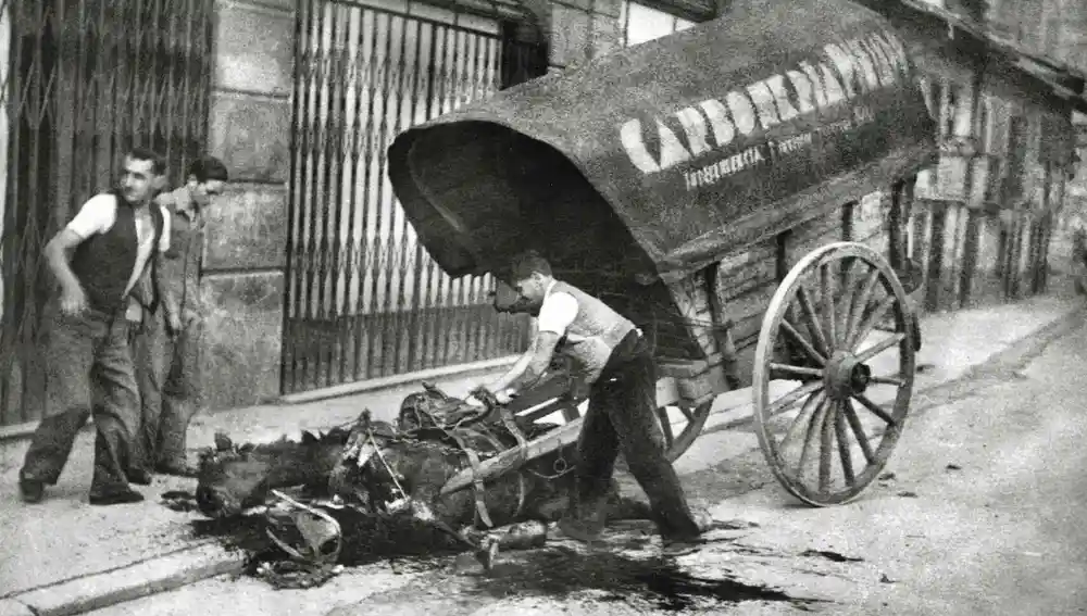 Unos hombres desenganchan los arreos de un caballo muerto (1936)
