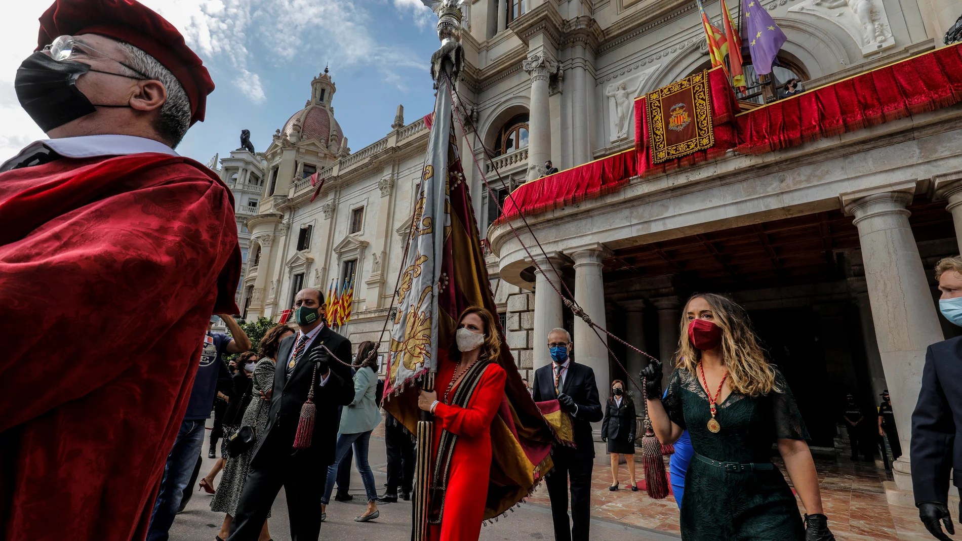 La teniente de alcalde del Ayuntamiento de Valencia, Pilar Bernabé (centro), transporta la Reial Senyera durante la Procesión Cívica con motivo del Día de la Comunidad Valenciana