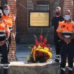 Miembros de Protección Civil de El Tiemblo, en Ávila, posan junto a la placa en recuerdo a los que dieron su vida por la covid en pandemia