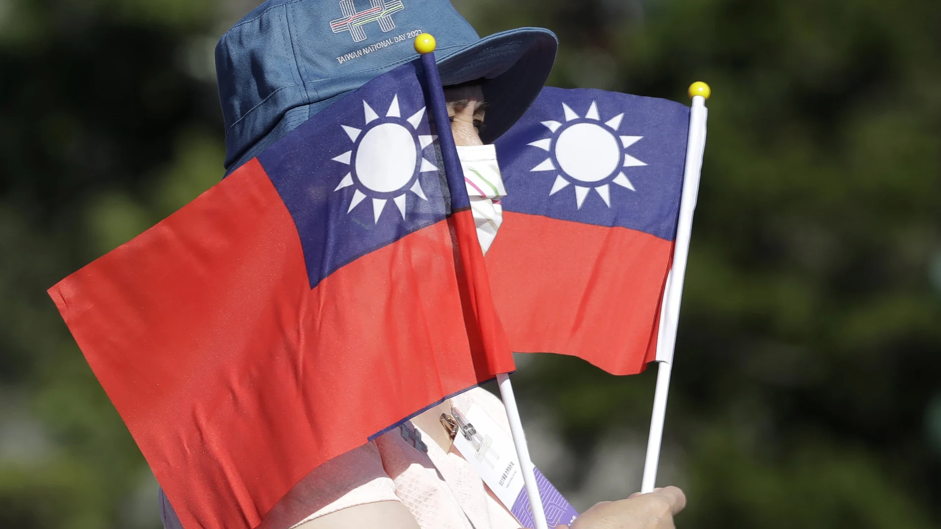 Un mujer sujeta dos banderas de Taiwán