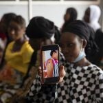 Oumie Nyassi shows a video circulating on the internet and that has been confirmed as fake news of a woman claiming she was magnetized after receiving the COVID-19 vaccine, in a doctors office at Serrekunda, Gambia hospital, Thursday Sept. 23, 2021. Nyassi, 24, said that she would get the vaccine only after delivering her baby. As health officials in Gambia and across Africa urge women to be vaccinated, they've confronted hesitancy among those of childbearing age. Although data on gender breakdown of vaccine distribution are lacking globally, experts see a growing number of women in Africa's poorest countries consistently missing out on vaccines. (AP Photo/Leo Correa)