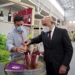 El consejero de Agricultura, Ganadería y Desarrollo Rural, Jesús Julio Carnero, observa una botella de una bodega presente en el Congreso Duero Wine