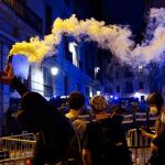 Manifestantes encienden bengalas frente a los agentes de los Mossos d'Esquadra durante los incidentes registrados en las inmediaciones de la comisaría de Vía Lietana de Barcelona, al finalizar la manifestación convocada por la ANC este sábado en Barcelona con motivo de la Diada del 11 de septiembre.