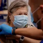 Un enfermero inocula la tercera dosis de la vacuna contra la covid-19 a una mujer mayor de 70 años. EFE/ Julio Muñoz