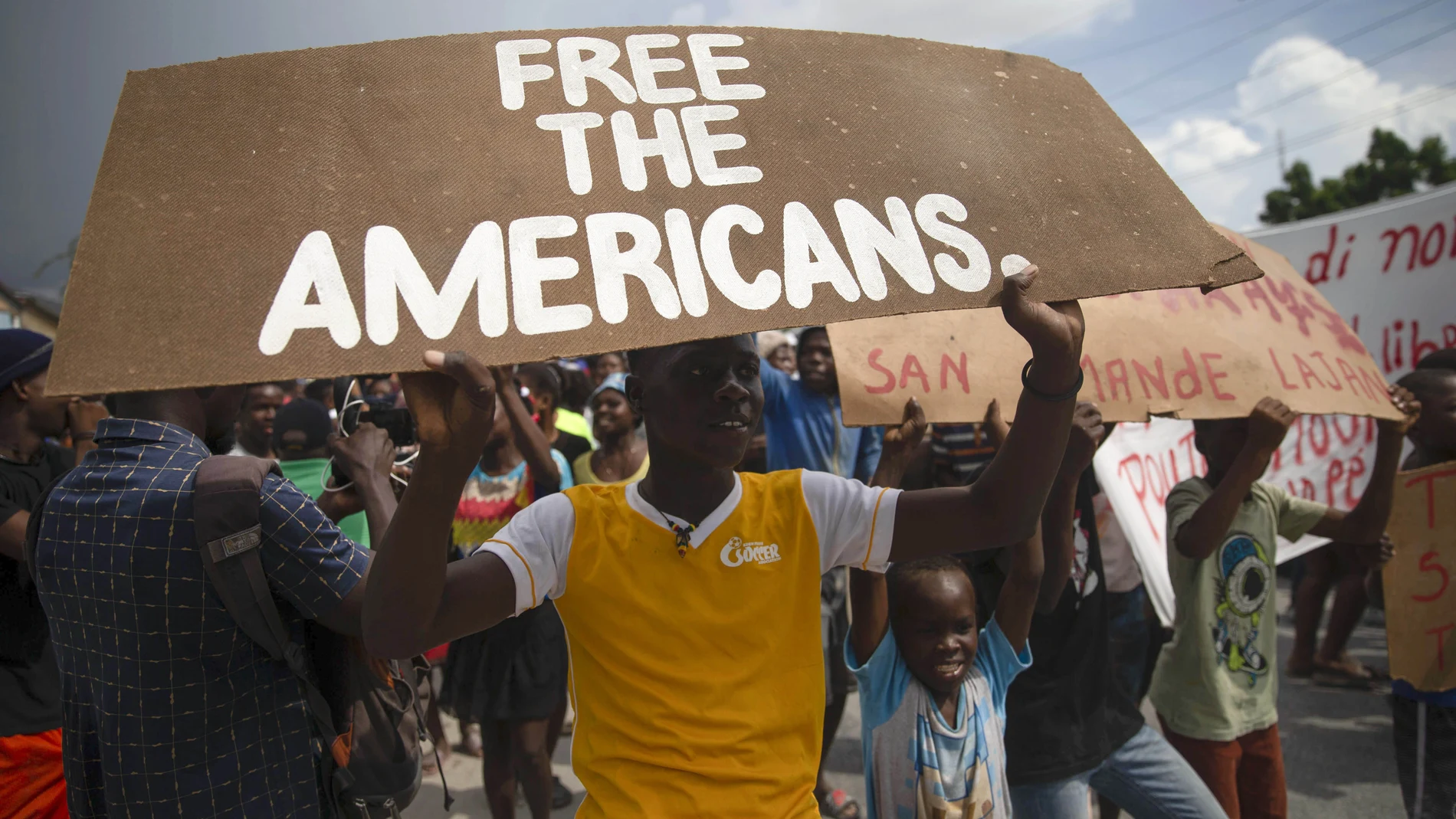 People protest for the release of kidnapped missionaries near the missionaries' headquarters in Titanyen, north of Port-au-Prince, Haiti, Tuesday, Oct. 19, 2021. A group of 17 U.S. missionaries including children was kidnapped by a gang in Haiti on Saturday, Oct. 16, according to a voice message sent to various religious missions by an organization with direct knowledge of the incident. (AP Photo/Joseph Odelyn)