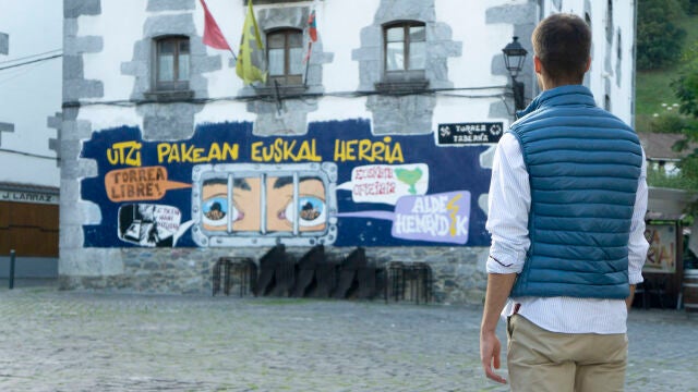 Un joven en el municipio de Leiza (Navarra) observa una pancarta