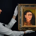 Una empleada de Sotheby's muestra el autorretrato de la artista mexicana Frida Khalo titulado "Diego y yo"