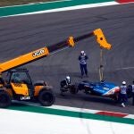 Una grúa recoge el coche de Fernando Alonso