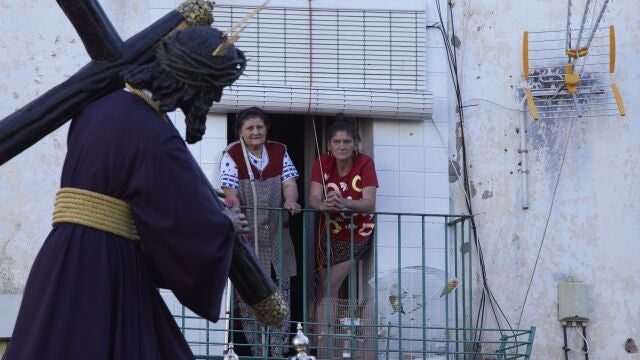 Dos señoras asomadas a su balcón ante el paso del Señor del Gran Poder