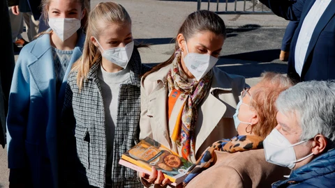 La reina Letizia (c), la princesa Leonor (2i) y la infanta Sofía (i) conversan con los habitantes de Santa María del Puerto, Asturias, en el concejo de Somiedo, reconocido como el Pueblo Ejemplar de Asturias de este año, donde han sido recibidos al son de las gaitas y con banderas de España y del Principado.