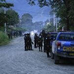 Police agents stand around a perimeter during raids in El Estor, at the northern coastal province of Izabal, Guatemala, Sunday, Oct. 24, 2021. The Guatemalan government has declared a month-long, dawn-to-dusk curfew and banned pubic gatherings following two days of protests against a mining project. (AP Photo/Moises Castillo)