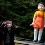 -FOTODELDIA- Seúl (Corea del Sur) 26/10/2021.- Dos jóvenes se hacen una foto frente al robot del primer capítulo de la serie 'El juego del calamar' que se erige en el Parque Olímpico de Seúl, Corea del Sur este martes. EFE/ Jeon Heon-kyun