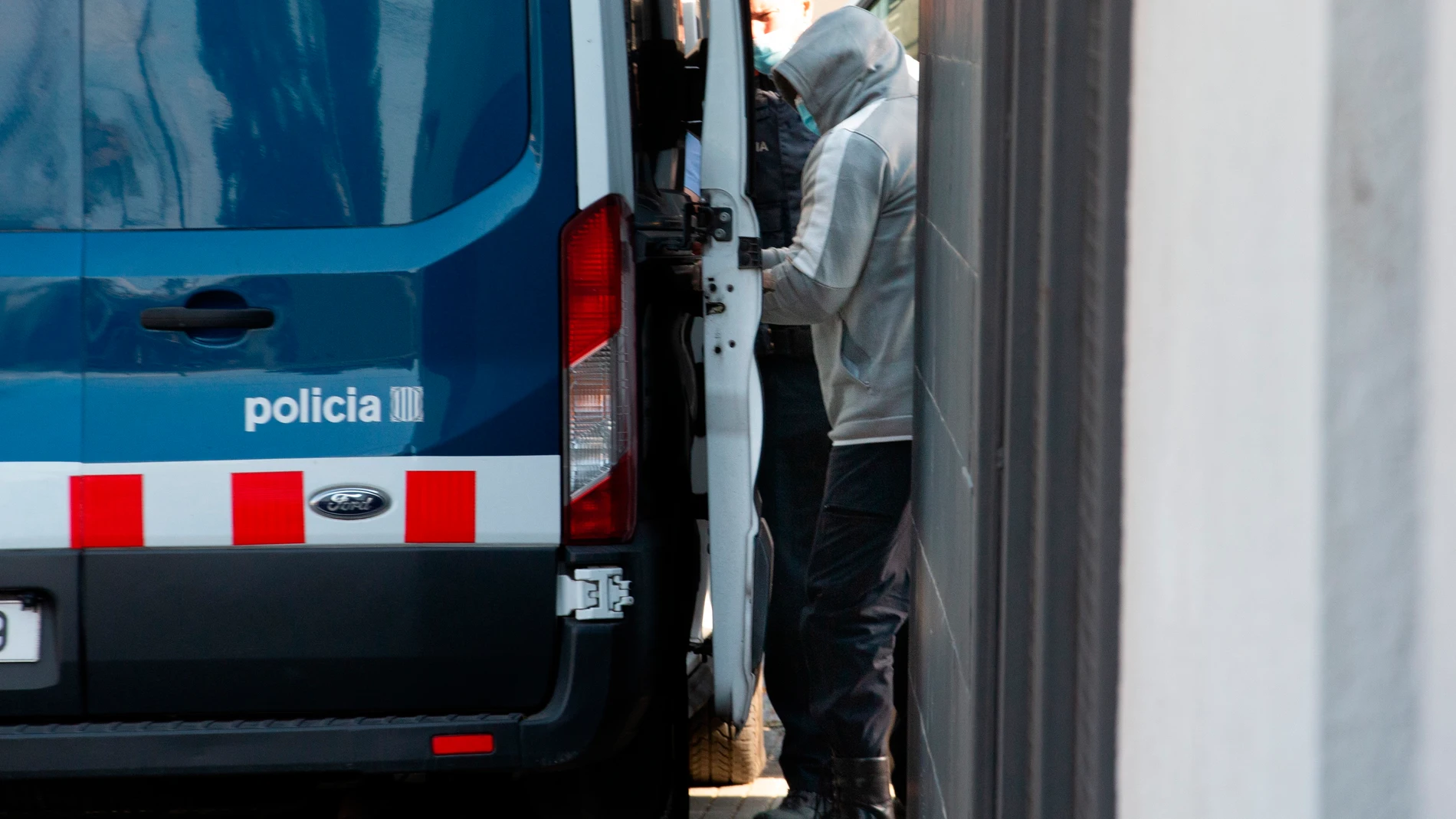 Uno de los detenidos es conducido a un furgón policial desde la comisaría de la Policía Local de Llinars del Vallés (Barcelona), donde los Mossos d' Esquadra han practicado por el momento cuatro detenciones en el marco de una operación contra una red de tráfico de marihuana centrada en esta población barcelonesa.EFE/Enric Fontcuberta