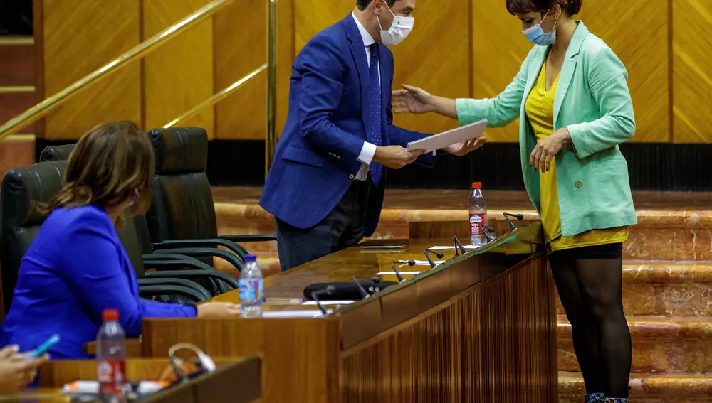 El presidente de la Junta, Juanma Moreno, recibe unas propuestas de resolución de manos de Teresa Rodríguez, en representación de los diputados no adscritos de Adelante Andalucía. EFE/Julio Muñoz
