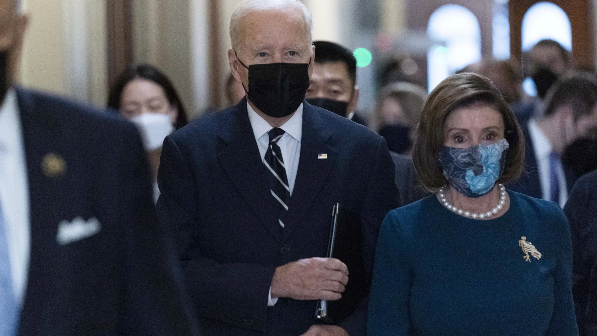 El presidente Joe Biden camina junto a la presidenta de la Cámara de Representantes, Nancy Pelosi, en el Capitolio