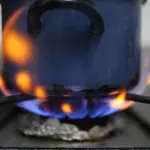 Una olla es calentada sobre el fuego de una cocina de gas