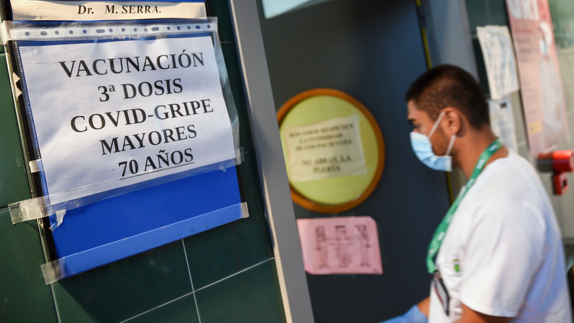 Un enfermero entra en una sala donde se administran vacunas contra la gripe y terceras dosis contra la covid