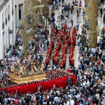 Centenares de personas contemplan la salida procesional del Santísimo Cristo de la Exaltación (Cofradía de Fusionadas) a su paso por calle Larios