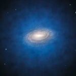 Una representación artística de la Vía Láctea, con la nube de materia oscura en la que está inmersa coloreada en azul. Todo indica que las galaxias se forman en el corazón de estas nubes, o “halos”, cuya extensión puede ser muy variable. En algunos casos el halo puede ser hasta diez veces más grande que la propia galaxia.
