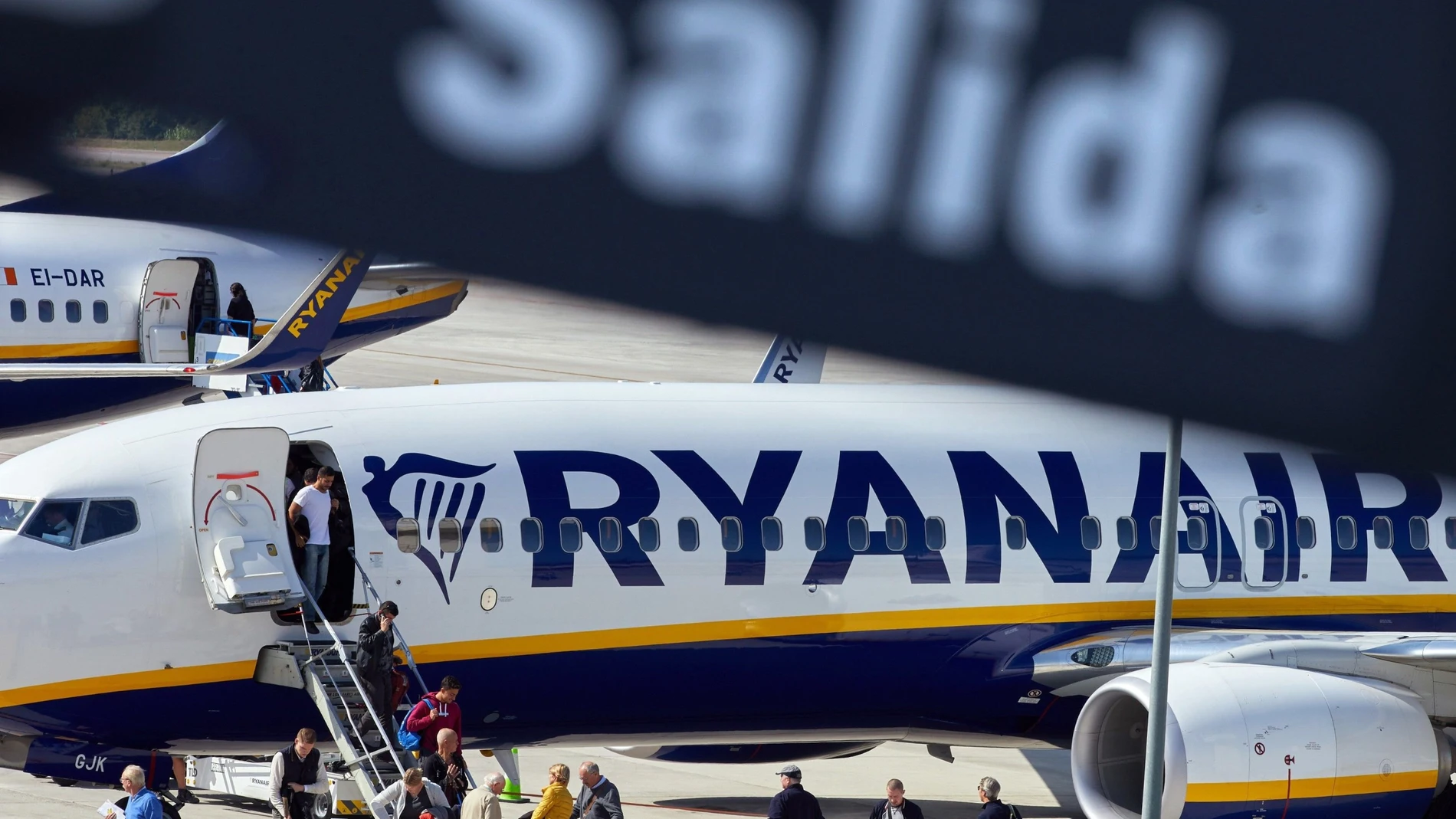 Varios viajeros desembarcan de un avión de la compañía aérea Ryanair en el aeropuerto de Gerona
