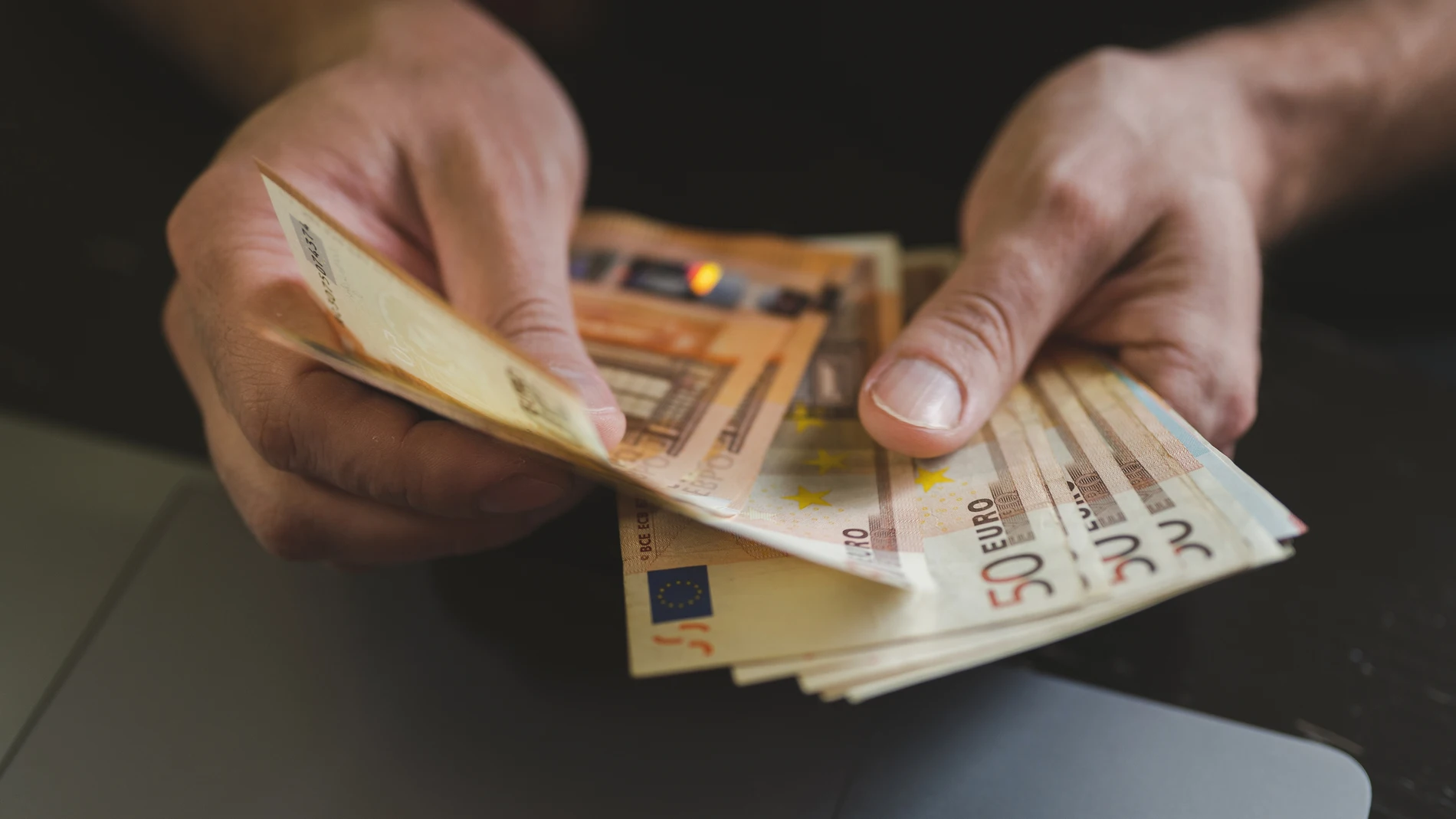 Una persona cuenta billetes de 50 euros