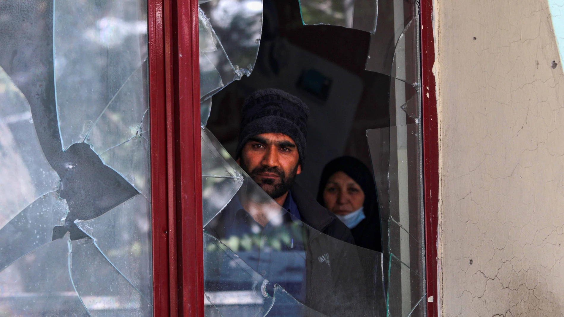 Una persona observa a través de los cristales rotos de una ventana tras la explosión del terrorista suicida EFE/EPA/STRINGER
