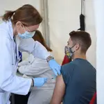 Un joven acude a recibir la vacuna contra el Covid-19, en un punto de vacunación instalado con motivo del Festival de Les Arts