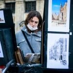Una mujer observa unas litografías en una de las calles céntricas de Bruselas, en plena efervescencia de casos Covid