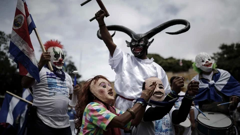 -FOTODELDIA- AME5420. SAN JOSÉ (COSTA RICA), 07/11/2021.- Dos personas con máscaras que hacen referencia al presidente de Nicaragua, Daniel Ortega (d), y su esposa la vicepresidenta Rosario Murillo (i), posan esposados durante una manifestación de nicaragüenses contra las elecciones presidenciales de su país, hoy, en San José (Costa Rica). Miles de nicaragüenses exiliados en Costa Rica protestaron este domingo por las principales calles de la capital contra el "fraude" y el "circo" electoral orquestado por el presidente de ese país, Daniel Ortega. En el marco de una jornada de manifestaciones, varios colectivos opositores nicaragüenses se unieron alrededor del mundo para repudiar las elecciones que se realizan este domingo en el país centroamericano. EFE/ Jeffrey Arguedas