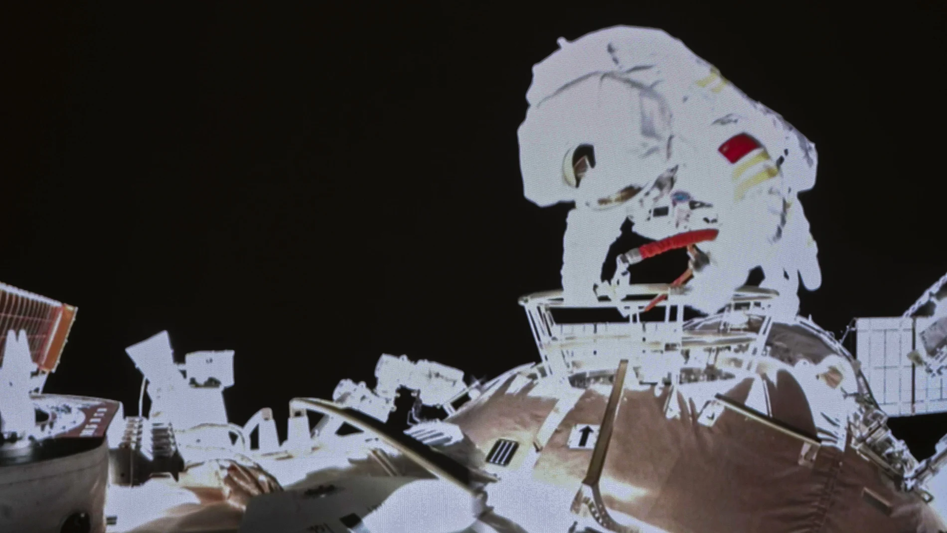 In this image released by the Xinhua News Agency, a photo taken on a screen shows Chinese astronaut Wang Yaping conducts an activities outside the space station's Tianhe core module, at Beijing Aerospace Control Center on Sunday, Nov. 7, 2021. Wang Yaping has become the first Chinese woman to conduct a spacewalk as part of a six-month mission to the country's space station. Wang and fellow astronaut Zhai Zhigang left the station's Tianhe core module on Sunday evening Beijing time, spending more than six hours installing equipment and carrying out tests alongside the station's robotic service arm. (Guo Zhongzheng/Xinhua via AP)