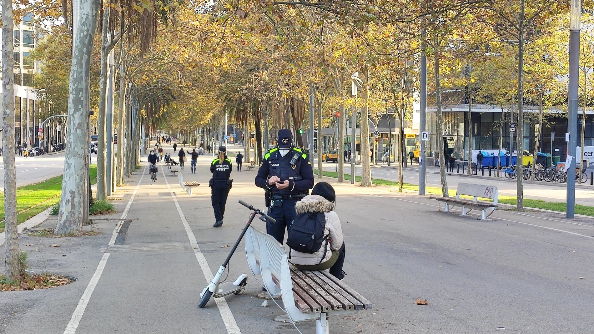 Un agente de la Guardia Urbana multa a una usuaria de patinete eléctrico en Barcelona