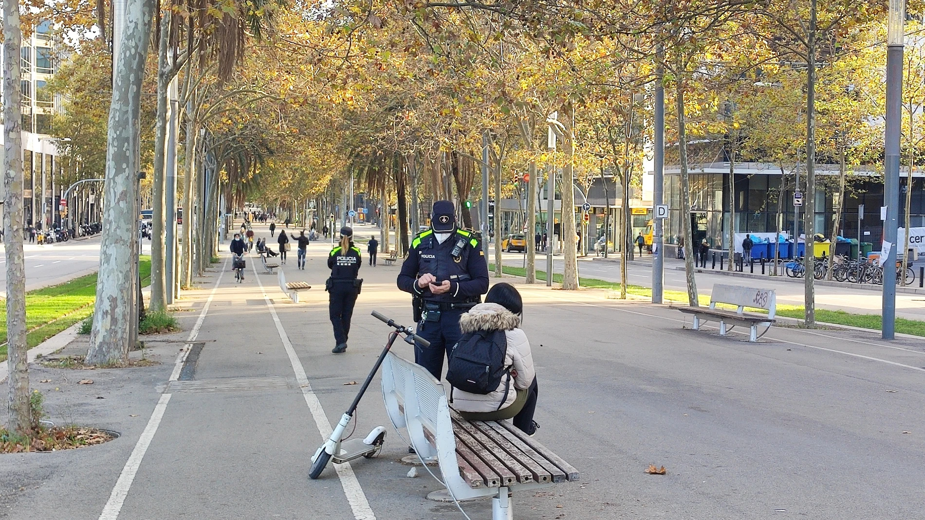Un agente de la Guardia Urbana multa a una usuaria de patinete eléctrico en Barcelona