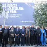 Los empresarios, junto a la lona gigante que denuncia los retrasos del proyecto ferroviario expuesta en plena Castellana de Madrid