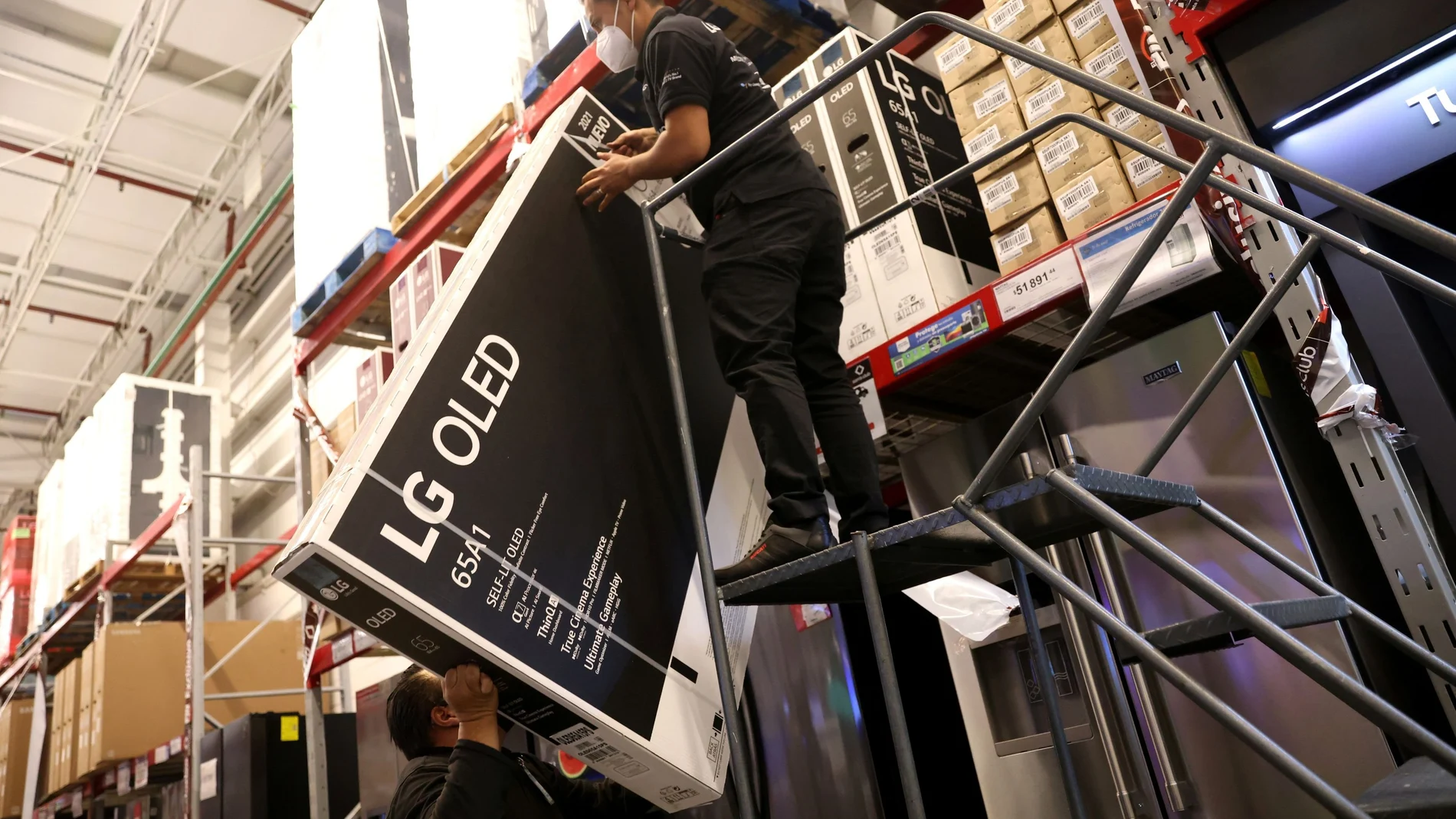 Un trabajador carga con una televisión en un comercio durante el inicio de las rebajas del Black Friday