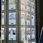 Un joven observa carteles de viviendas en venta y alquiler