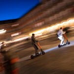 Imagen nocturna de tres patinetes eléctricos por la Plaza Mayor