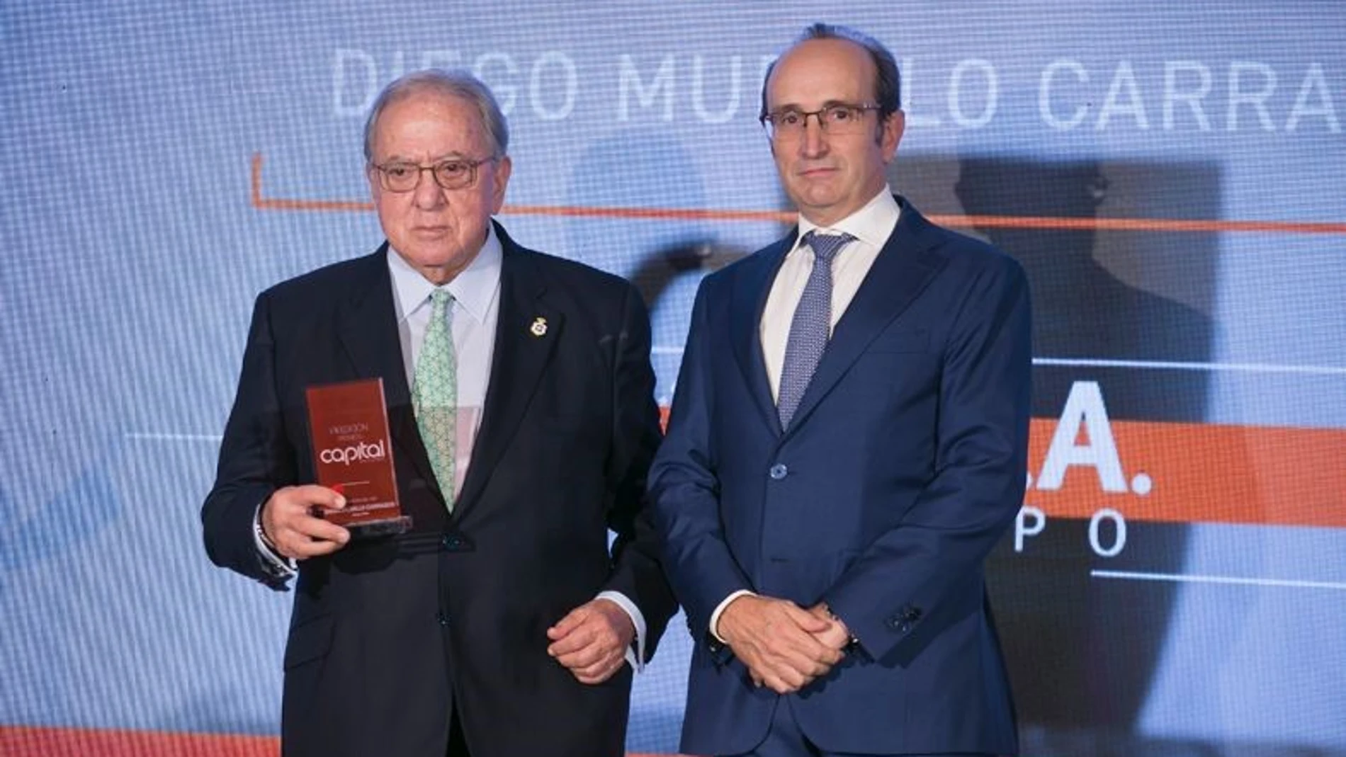 Diego Murillo, presidente de honor de A.M.A, posa con el galardón de Empresario del Año