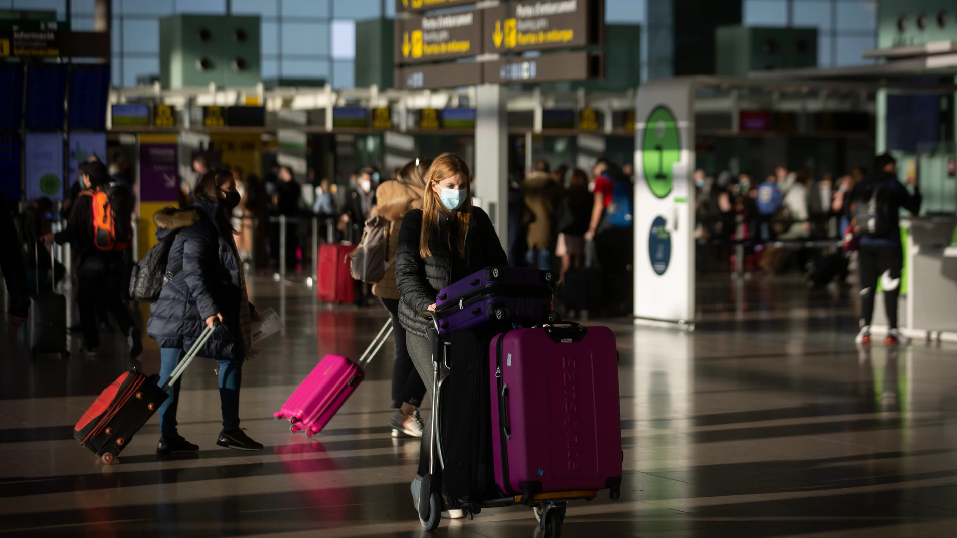 Varios pasajeros con maletas en el aeropuerto de El Prat