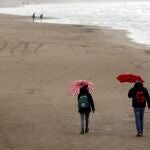 Dos personas pasean por la playa de la Malvarosa, prácticamente desierta, el pasado sábado
