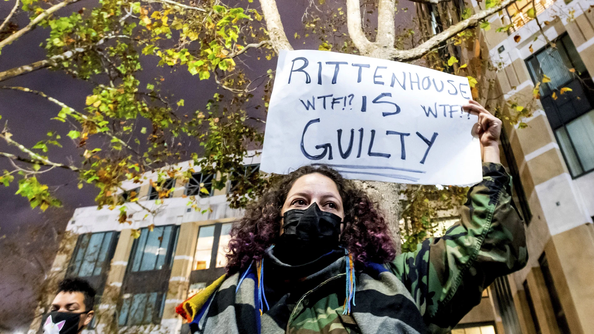 Una manifestante lleva un cartel en el que dice que Kyle Rittenhouse es culpable, el viernes en Kenosha