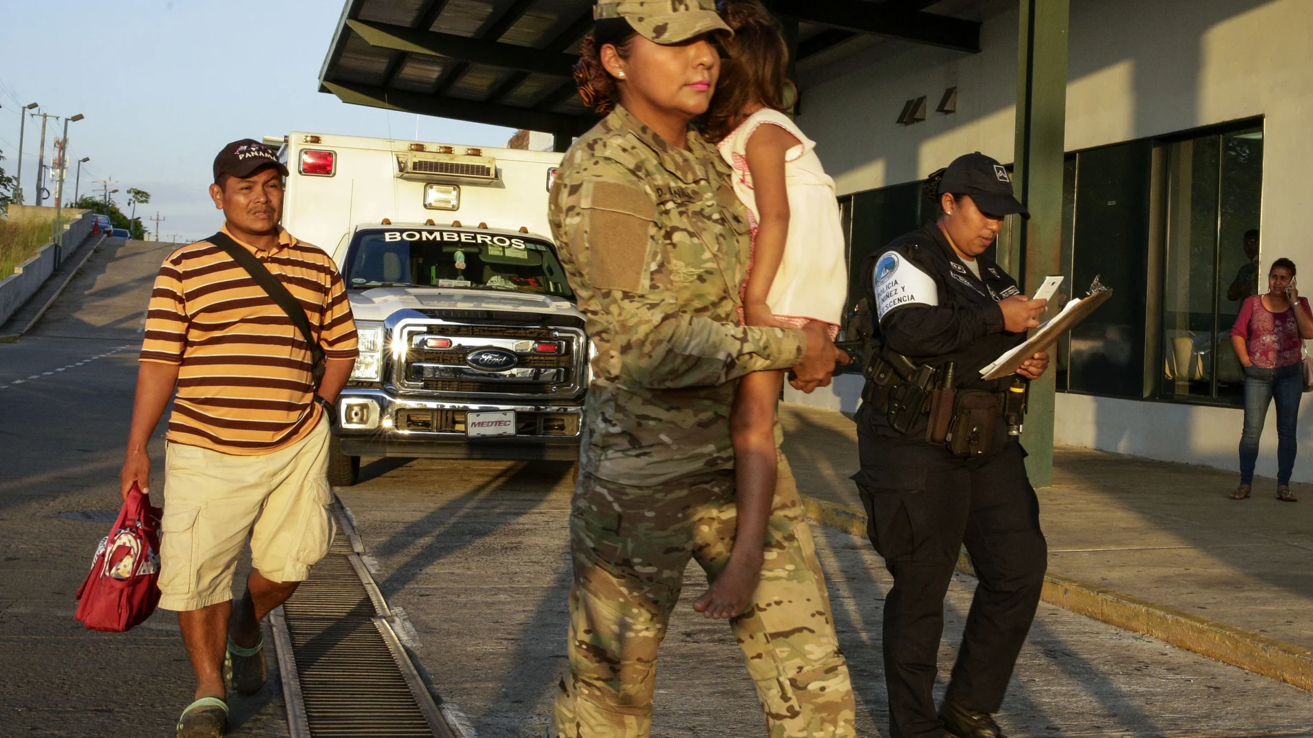 FILE - Jose Gonzalez, left, follows his 5-year-old daughter, carried by a police officer, as they leave a hospital in Santiago, Panama, Thursday, Jan. 16, 2020. Gonzalez's wife and five of their children are among seven people killed in a religious ritual in the Ngabe Bugle indigenous community. On Saturday, Nov. 20, 2021, a jury of conscience convicted seven members of a religious sect accused of murdering a woman and six minors as part of a cult in a remote indigenous area of â€‹â€‹the Panamanian Caribbean in early 2020, a tragedy that strongly shook the country. (AP Photo/Arnulfo Franco, File)