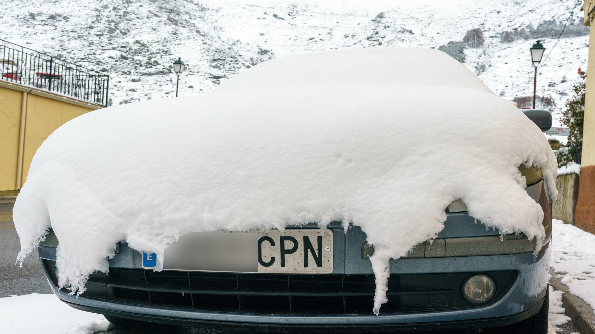 Un coche cubierto por la nieve caída durante las últimas horas en la localidad abulense de Mengamuñoz