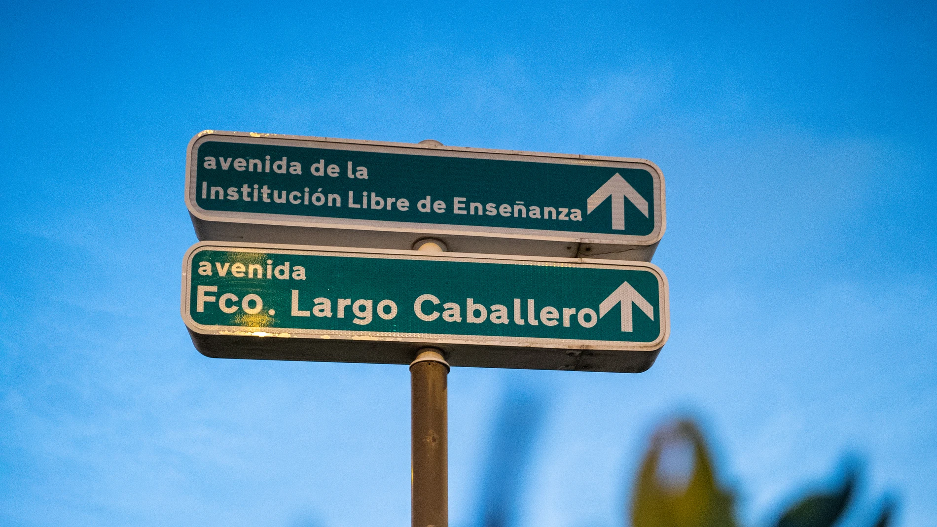 Indicación de la avenida de la Institución Libre de Enseñanza, que volverá a ser Hermanos García Noblejas, junto a la de Largo Caballero