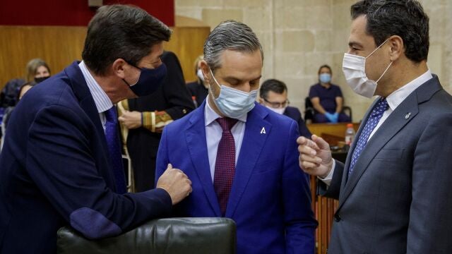 El presidente de la Junta de Andalucía, Juanma Moreno (d); el consejero de Hacienda, Juan Bravo (c), y el vicepresidente, Juan Marín (i), conversan esta tarde al inicio del pleno del Parlamento andaluz en Sevilla. EFE/Julio Muñoz