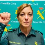 Una agente reproduced el gesto que hay que hacer para avisar de los csos de violencia de género